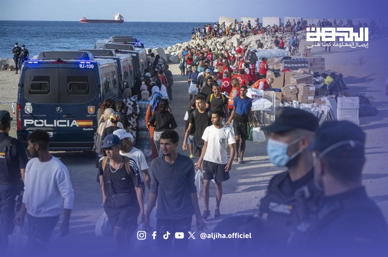 صورة أرشيفية لمهاجرين وعناصر الشرطة الإسبانية بشاطئ ترومبولين في سبتة
